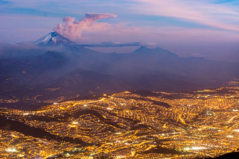 La ville de Quito à la tombée de la nuit avec le Cotopaxi en éruption dans le fond, Equateur - Arrivée à Quito - Croisière spéciale photo aux Galápagos avec Nature Experience